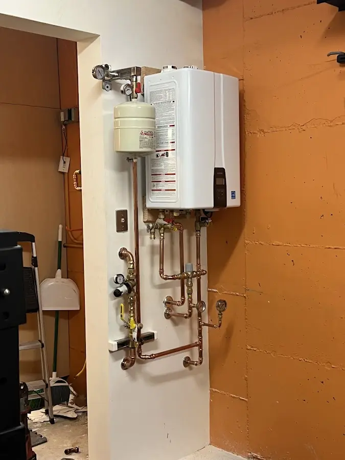 Plumbing technician inspecting water heater connections in South Hill